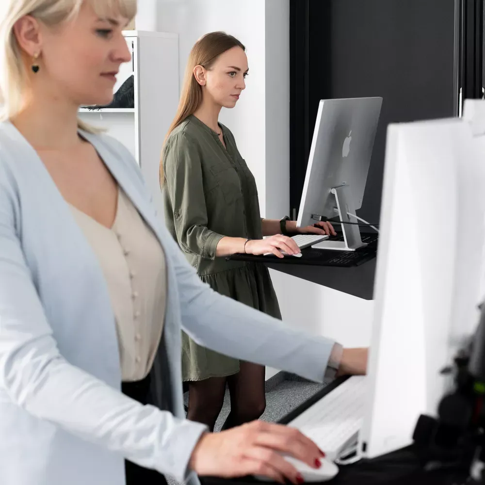 Edytorzy fotografii produktowej pracujący przy stojących stanowiskach